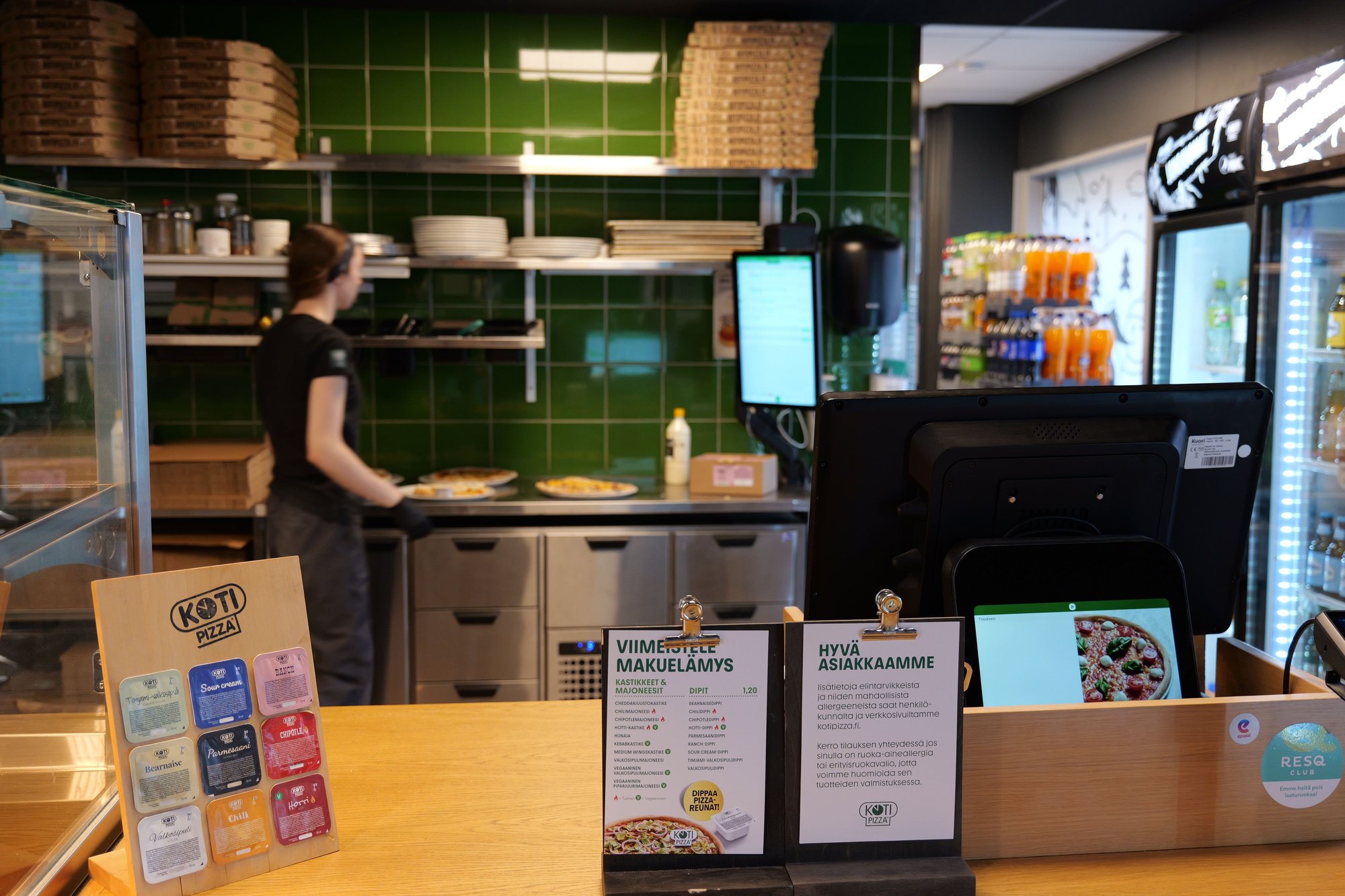 Kotipizza counter with Kuori POS terminal and kitchen display in the